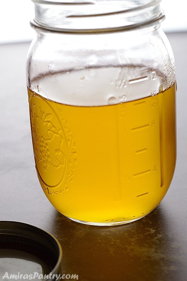 A mason jar with melted clear ghee in it.