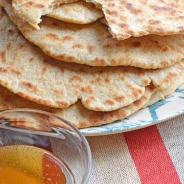 Skillet flatbread with a cut and small bowl of honey