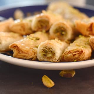 A close up of a plate of food, with Baklava rolls