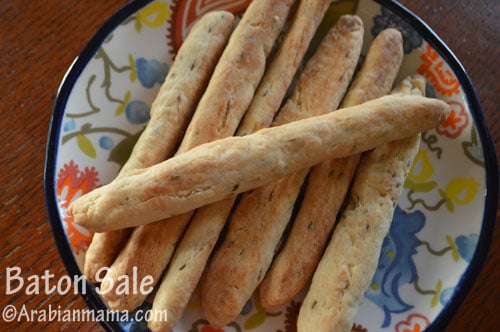 A close up of a plate with bread-sticks  