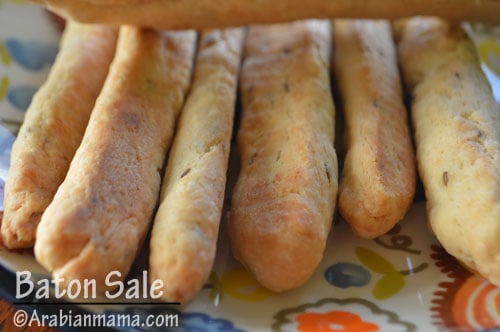 A close up of a plate with bread-sticks  