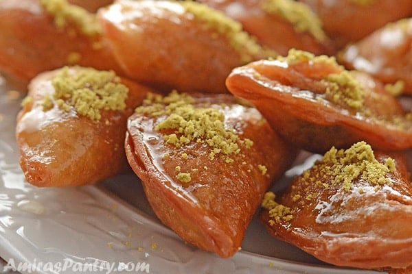 A close up look at a platter with qatayef stacked on top of each other .