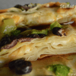 A close up of a pizza fetter with olives and cheese