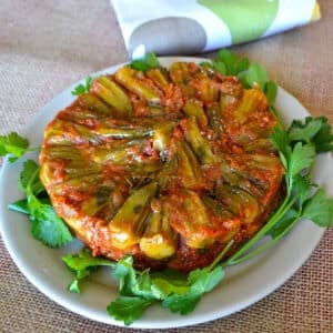 Okra torte on a serving plate garnished with parsley.