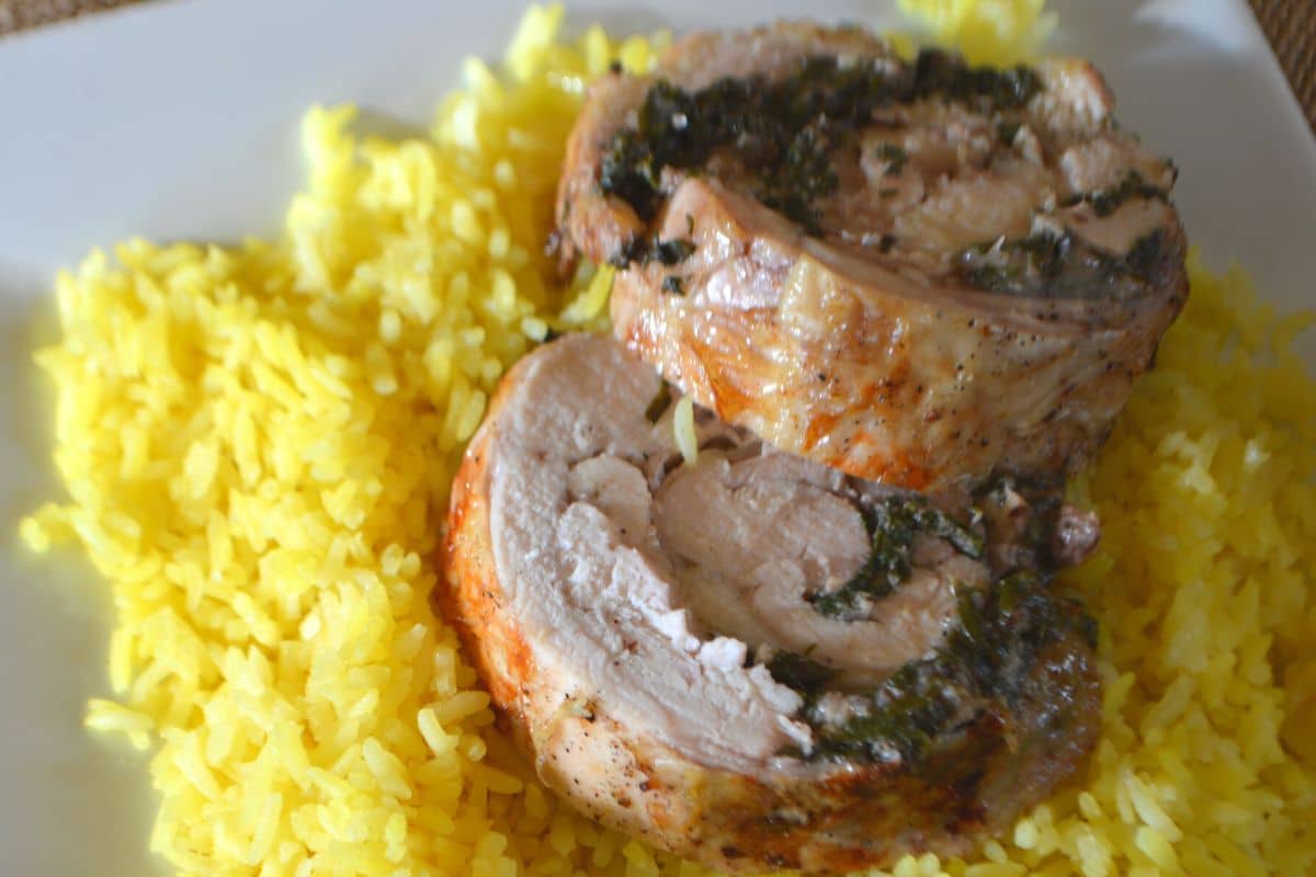 chicken rolls on a bed of yellow rice.