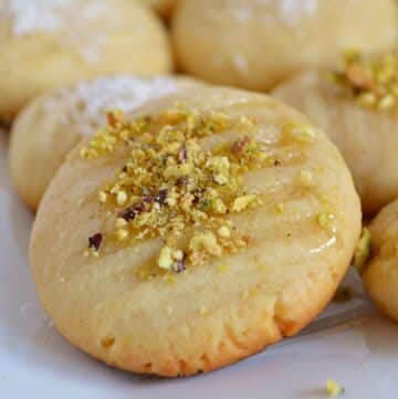 A close up look at one cookies garnished with crushed pistachios.