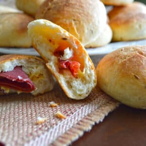 Stuffed rolls on a table with one cut in half to show filling.
