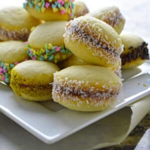 A white plate with lancashire cookies stacked on top of each other.