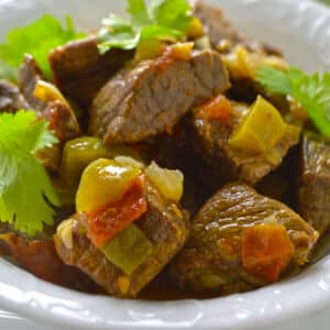 Meat cubes with bell pepper on a white bowl.