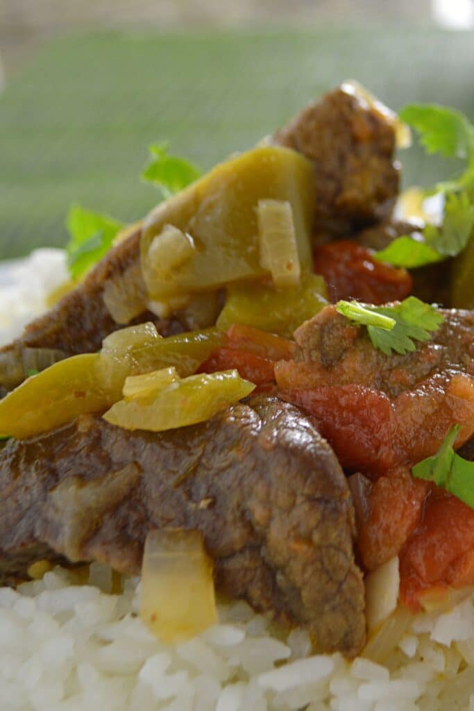 Beef cubes with bell pepper on a bed of rice.