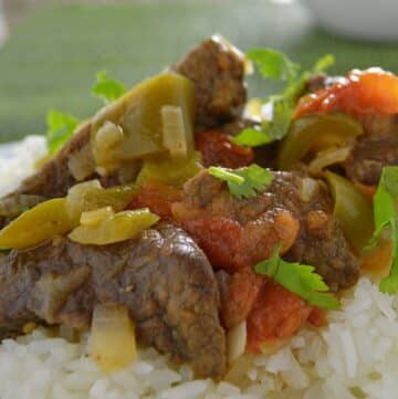 Beef cubes with bell pepper on a bed of rice.