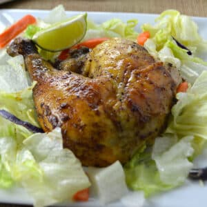 Roasted chicken leg on a bed of lettuce.