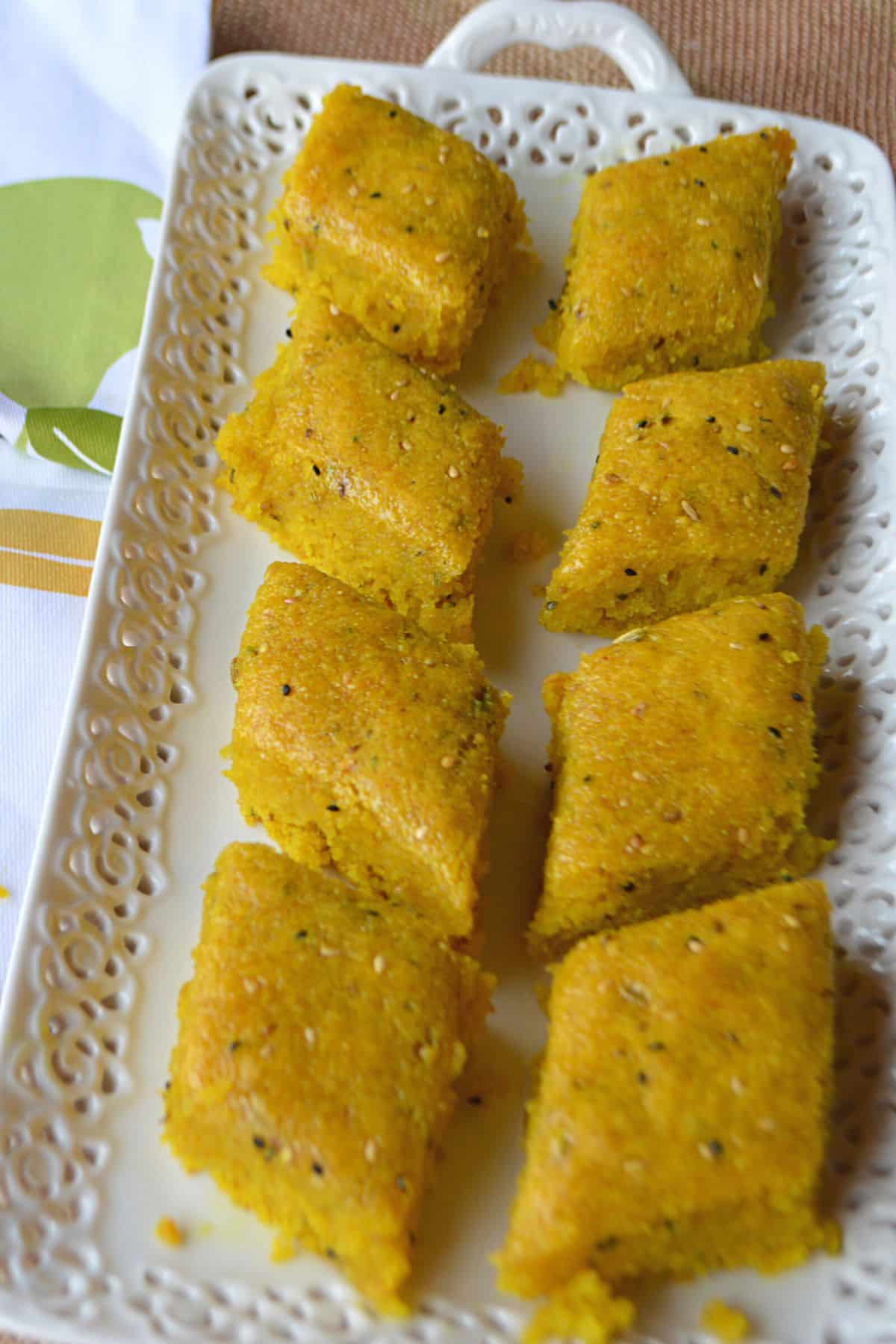 Turmeric cake squares on a white plate.