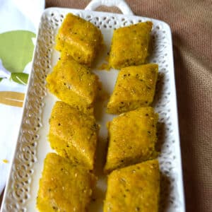 Turmeric cake mekarkama on a white plate.