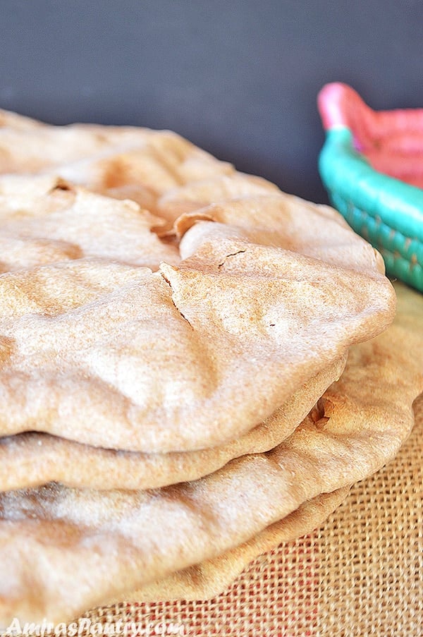 Une pile de pain plat sans levain avec une toile de jute en dessous.