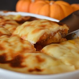A close up of food showing a knife and pumpkin pie with bechamel on top