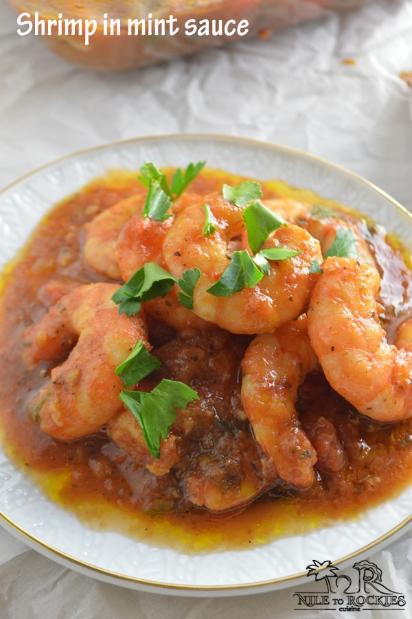 A close up of a plate with shrimp covered in sauce