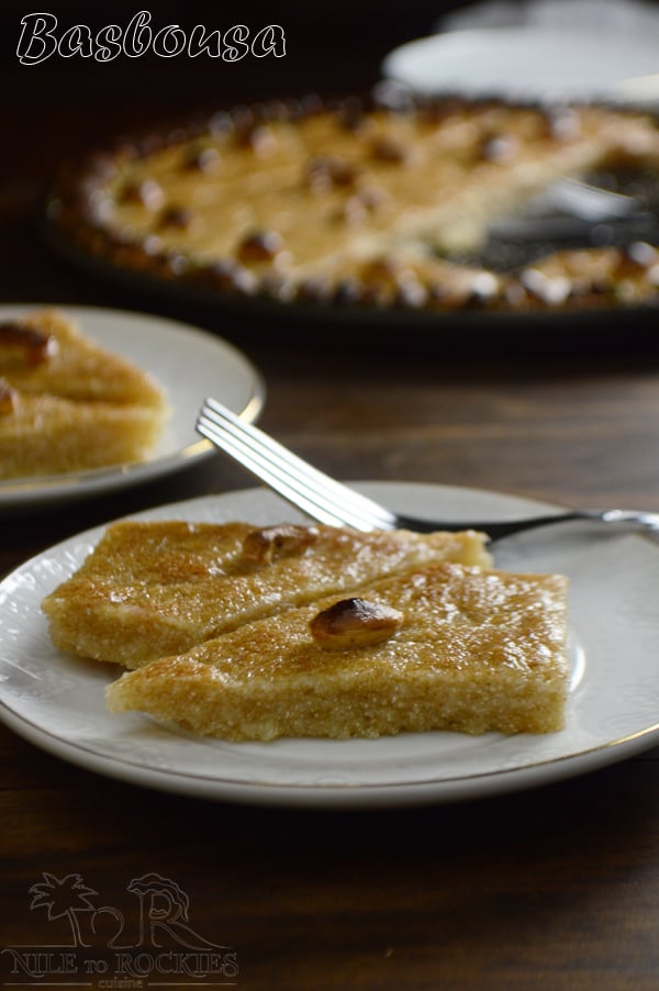 A plate of food on a table, with Basbousa and Nut and fork