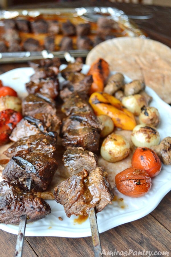 Beef kabob skewers in a plate with pita bread