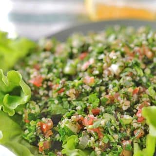 A close up of a plate of food with tabbouleh Salad and lettuce
