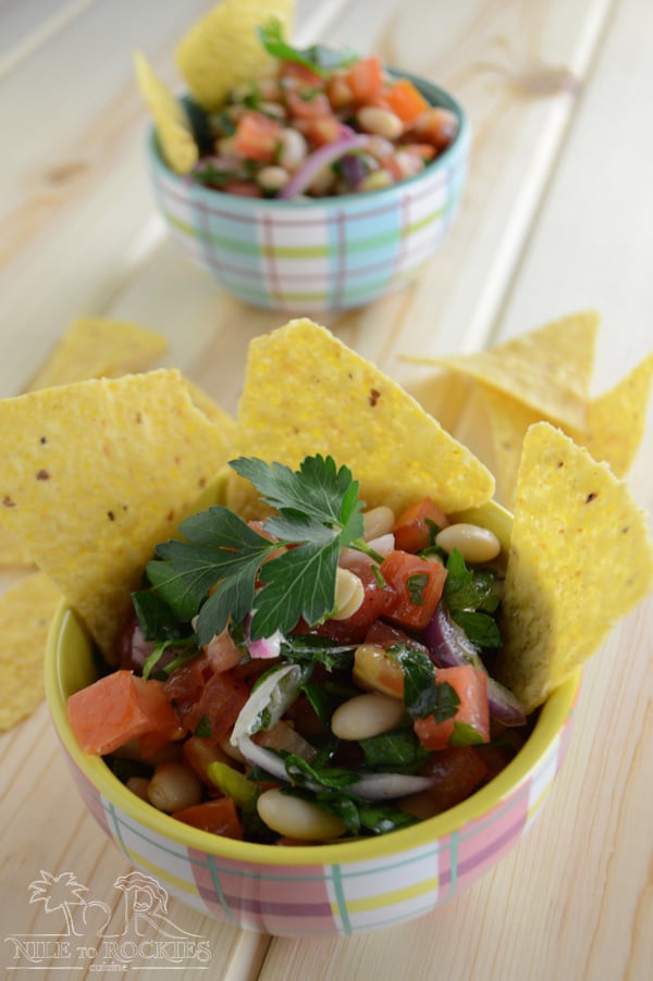 A bowl of food on a table, with Fattoush and tortilla