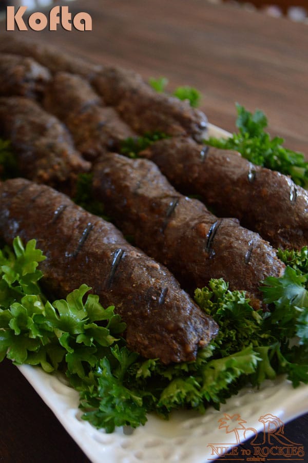 A close up of a plate of food with Parsely, grilled Kofta