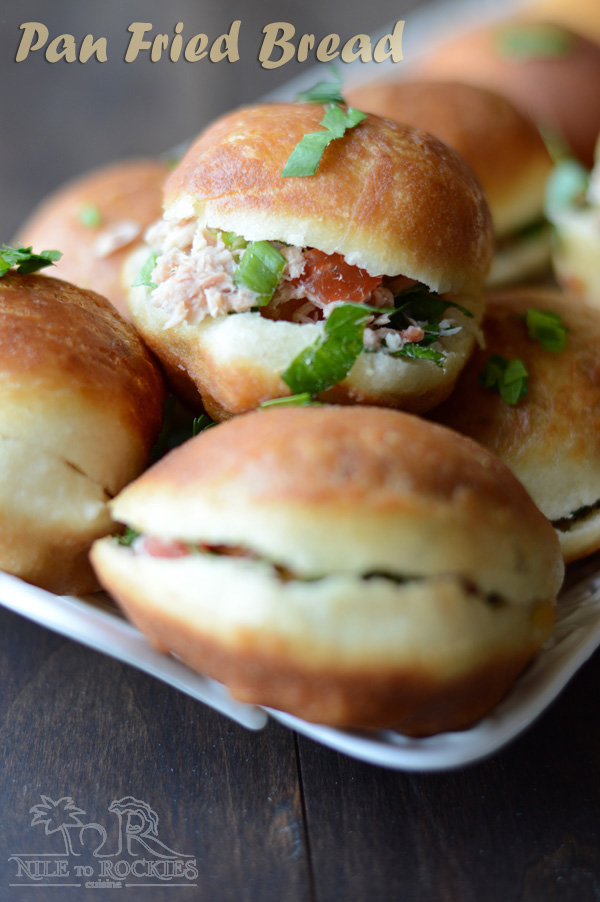 Delicious fried buns stuffed with tuna salad piled up on a serving plate.