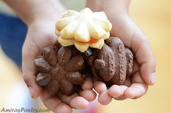 A photo showing hands holding petit fours cookies