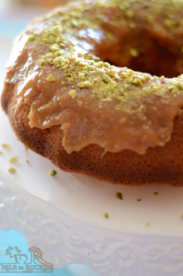 A piece of cake on a plate, with frosting and nuts