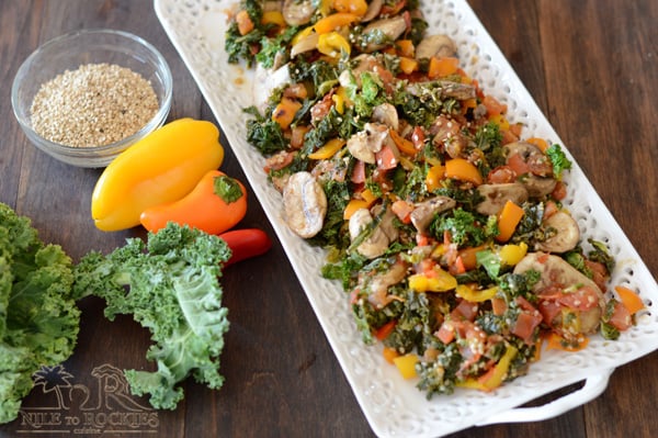 A tray of food on a wooden table, with Kale and Salad