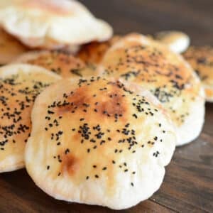 Egyptian bread loaves on a wooden surface.