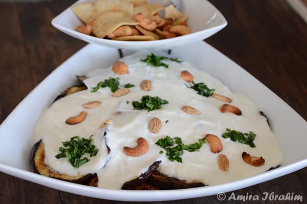 A plate of food on a table, with Eggplant and Yogurt