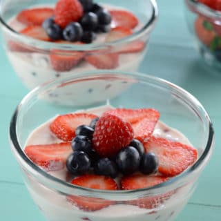 A bowl of fruit on a table, with Cream and Salad