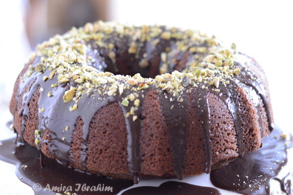 A close up of a cake covered in chocolate and nuts