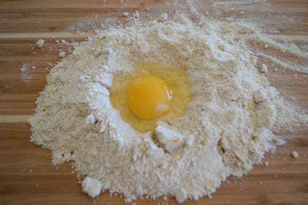 A photo showing a wooden board with mixture and egg on top