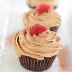 A close up of a Coffee Cupcake with Raspberry on top