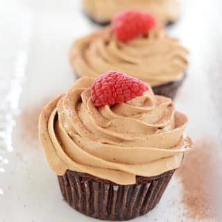 A close up of a Coffee Cupcake with Raspberry on top