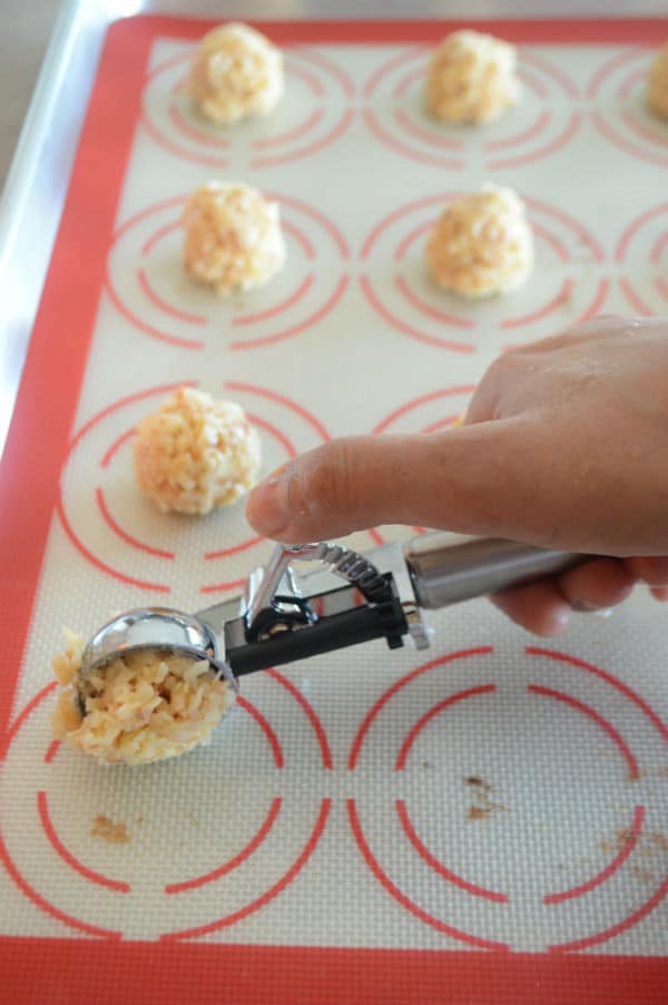 A sheet of food, with Macaroon balls and a hand