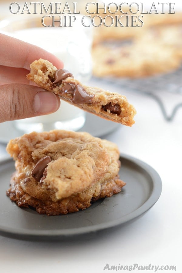 A piece of cookie on a plate, and hand holding another piece