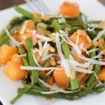 A close up of a plate of food, with butternut squash and asparagus