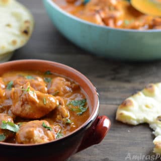 A bowl of food on a table with Chicken tikka