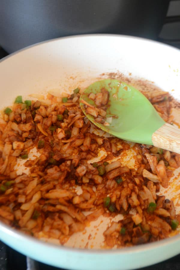 A bowl of rice, vegetables and a spoon