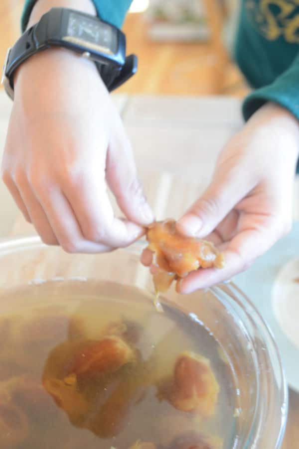 A hand with dates anda glass bowl with water