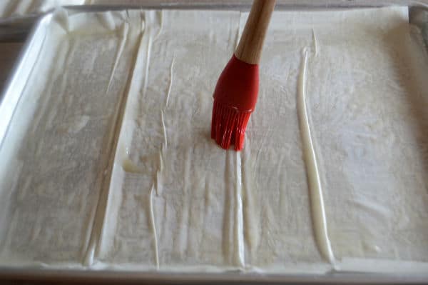 A photo showing sheets of pastry and brush