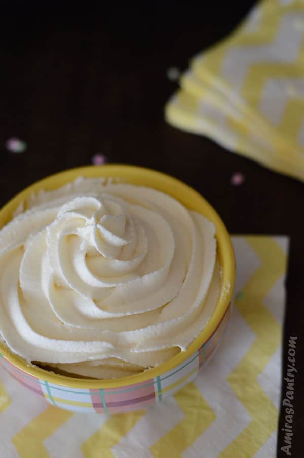 Fluffy marshmallow buttercream frosting piped into a small bowl with yellow napkins