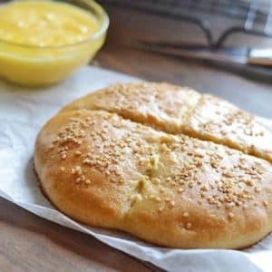 A bread on a paper sheet and knife