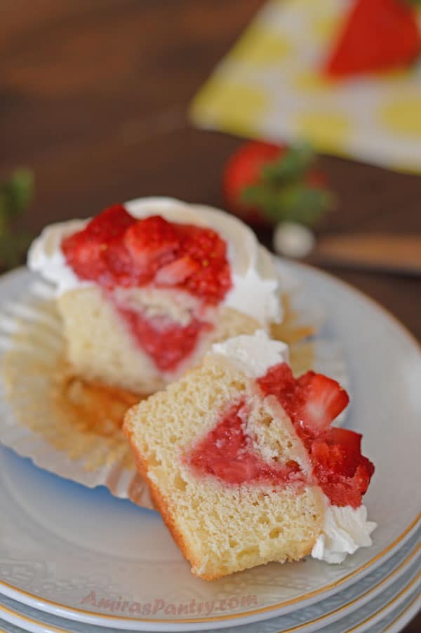 A piece of cupcake on a plate, with Strawberry