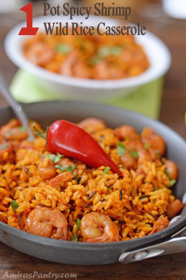 A dish is filled in food, with yellow Rice and spicy shrimp