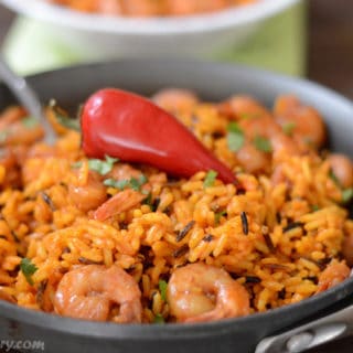 A dish is filled in food, with yellow Rice and spicy shrimp