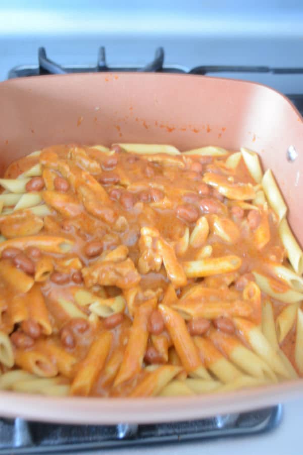 A pan of food on a stove with pasta and mixture
